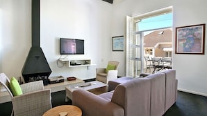 Ein Wohnzimmer mit Kamin, Sofa und Fernseher.