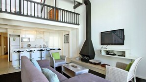 Ein modernes Wohnzimmer mit einer Couch, Sesseln, einem Couchtisch und einem Kamin.