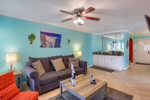 A living room with a sofa, coffee table, and a ceiling fan.