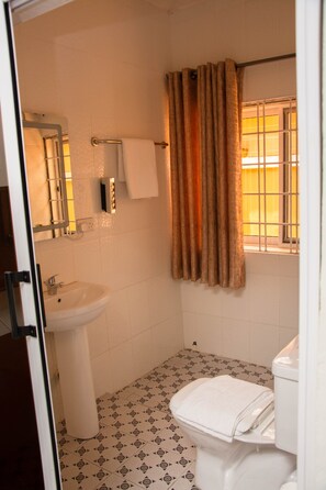 Habitación económica | Baño | Regadera, regadera tipo lluvia, amenidades de baño gratuitas, batas 