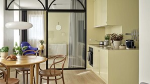 Una cocina moderna con comedor, suelo de madera y un ventanal grande.