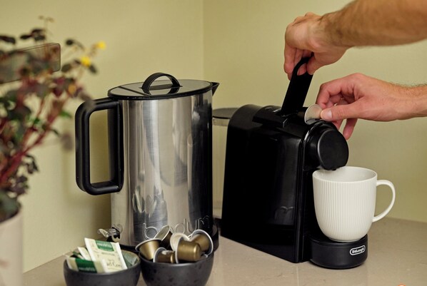 Una persona preparando café con una máquina de Nespresso.
