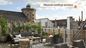 A shared rooftop terrace with outdoor seating and potted plants. - One-Bedroom Apartment for 3 (København)