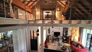 Un espacio tipo loft con cocina, comedor y un sofá rojo.