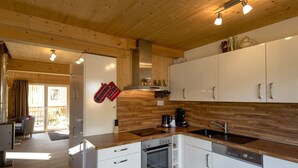 Une cuisine moderne avec des armoires blanches, des appareils en acier inoxydable et des plans de travail en bois.