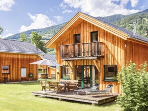 A wooden cabin with a balcony, outdoor seating, and a view of the surrounding landscape. - Chalet With Sauna and hot tub (Sankt Georgen am Kreischberg)
