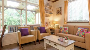 A cozy living room with a sofa, chairs, a coffee table, and a window with curtains. - Holiday Home in Arrien Near Beerze Nature (Arriën)