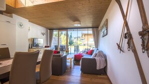 A modern interior with a dining area, seating, and a ski rack. - Bright Mountain Retreat Near Wildkogel Gondola (Neukirchen am Grossvenediger)