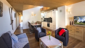 A modern interior with a dining area, kitchen, and seating space. - Bright Mountain Retreat Near Wildkogel Gondola (Neukirchen am Grossvenediger)