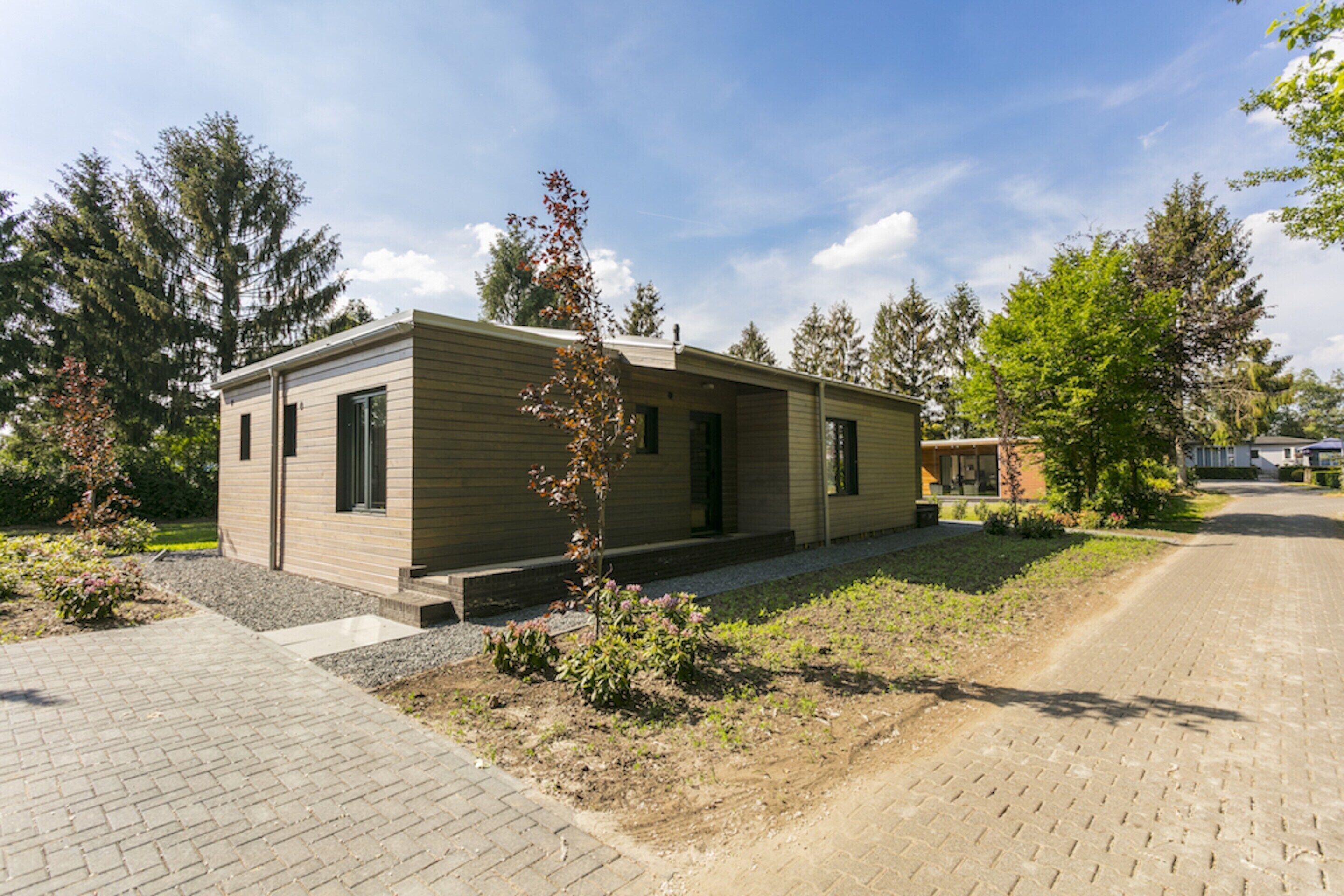 A single-story building with a flat roof, a small porch, and a paved driveway.