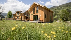 Eine Holzhütte mit einer großen Terrasse und Blick auf die umliegende Landschaft.