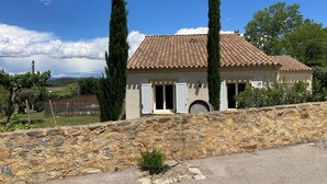 A house with a tiled roof, stone wall, and two tall trees. - Comfortable Villa With Jacuzzi (Montbrun-des-Corbières)
