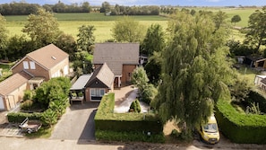 A residential property with a paved driveway, a detached garage, and a large tree in the foreground. - Villa in Bruinisse Near Grevelingenmeer (Bruinisse)