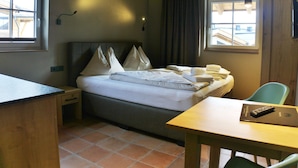 A hotel room with a bed, a desk, a chair, and a window. - Cozy Apartment in Piesendorf (Piesendorf)