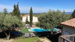 A backyard with a swimming pool, a fenced patio area, and a view of the countryside. - Montbrun Vineyard Escape (Montbrun-des-Corbières)
