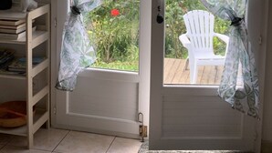 A door with a window, a white chair outside, and a bookshelf inside.