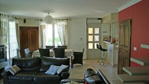 A living room with a sofa, dining table, chairs, and a kitchen area. - Villa in Reillanne With Private Pool (Reillanne)