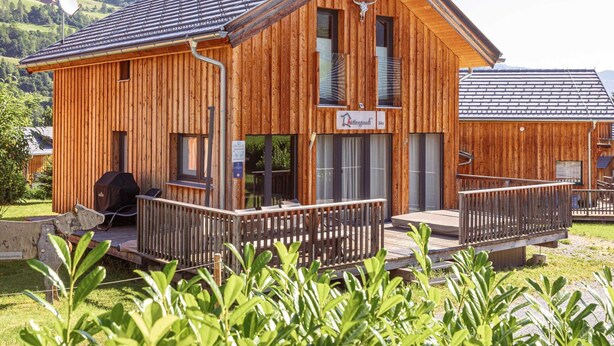 A wooden lodge with a balcony, a satellite dish, and a mountain backdrop. - Modern Chalet With Sauna (Sankt Georgen am Kreischberg)
