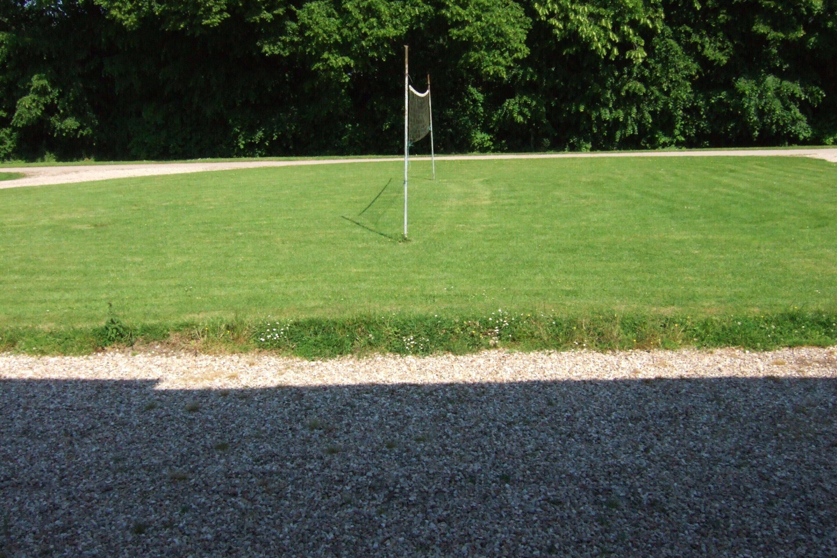 Un'area verde ben curata con un'asta sventolante, circondata da alberi.