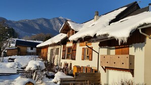 Een houten huis met sneeuwbedekte daken en een berg op de achtergrond.