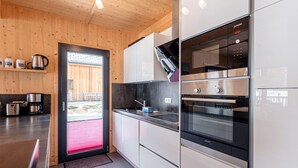 Eine moderne Küche mit Edelstahlgeräten, Holzvertäfelung und einem großen Fenster.