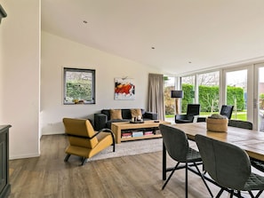 A modern living room with a sofa, coffee table, and dining area.