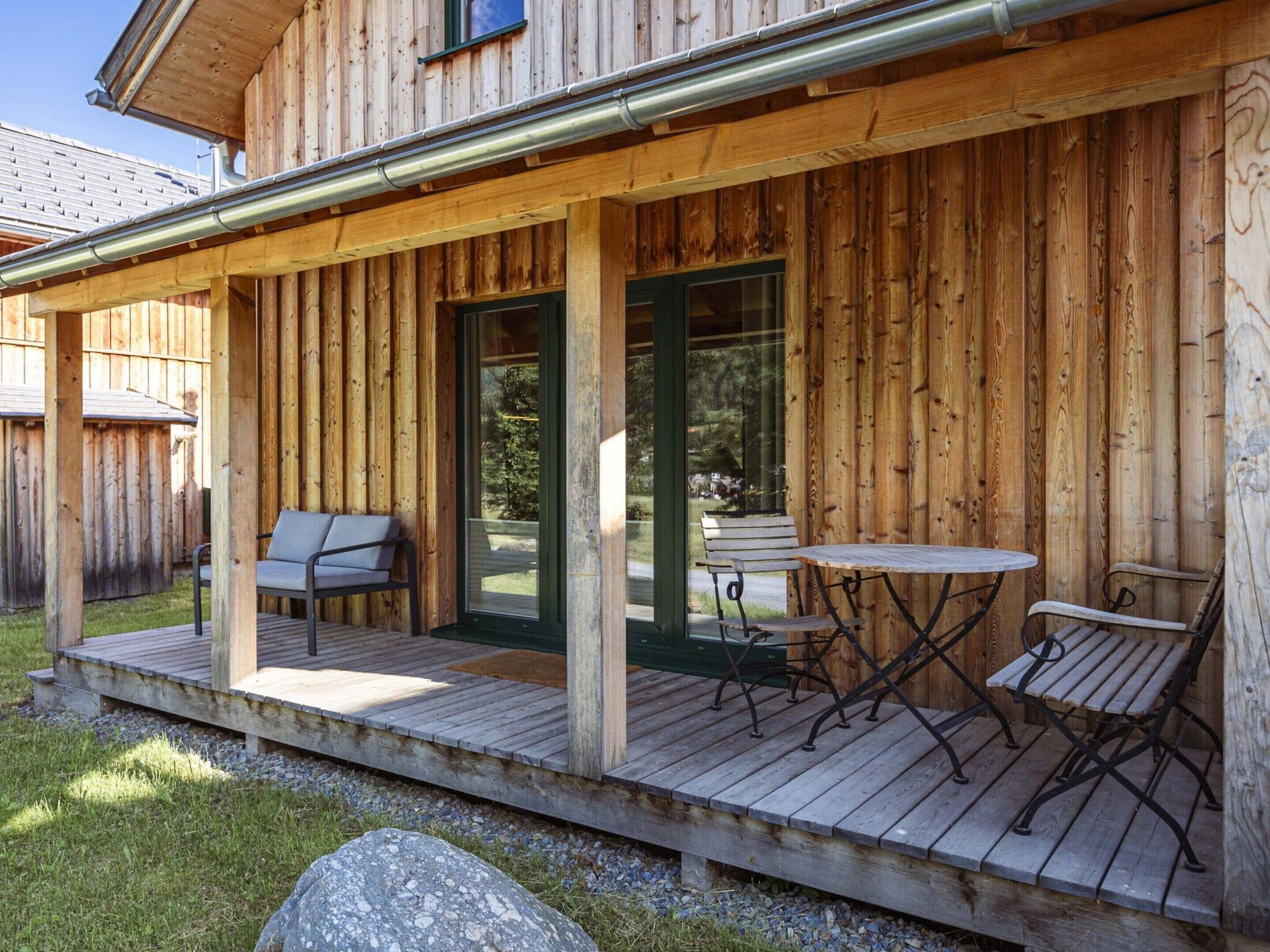 A wooden deck with outdoor seating and a covered area.
