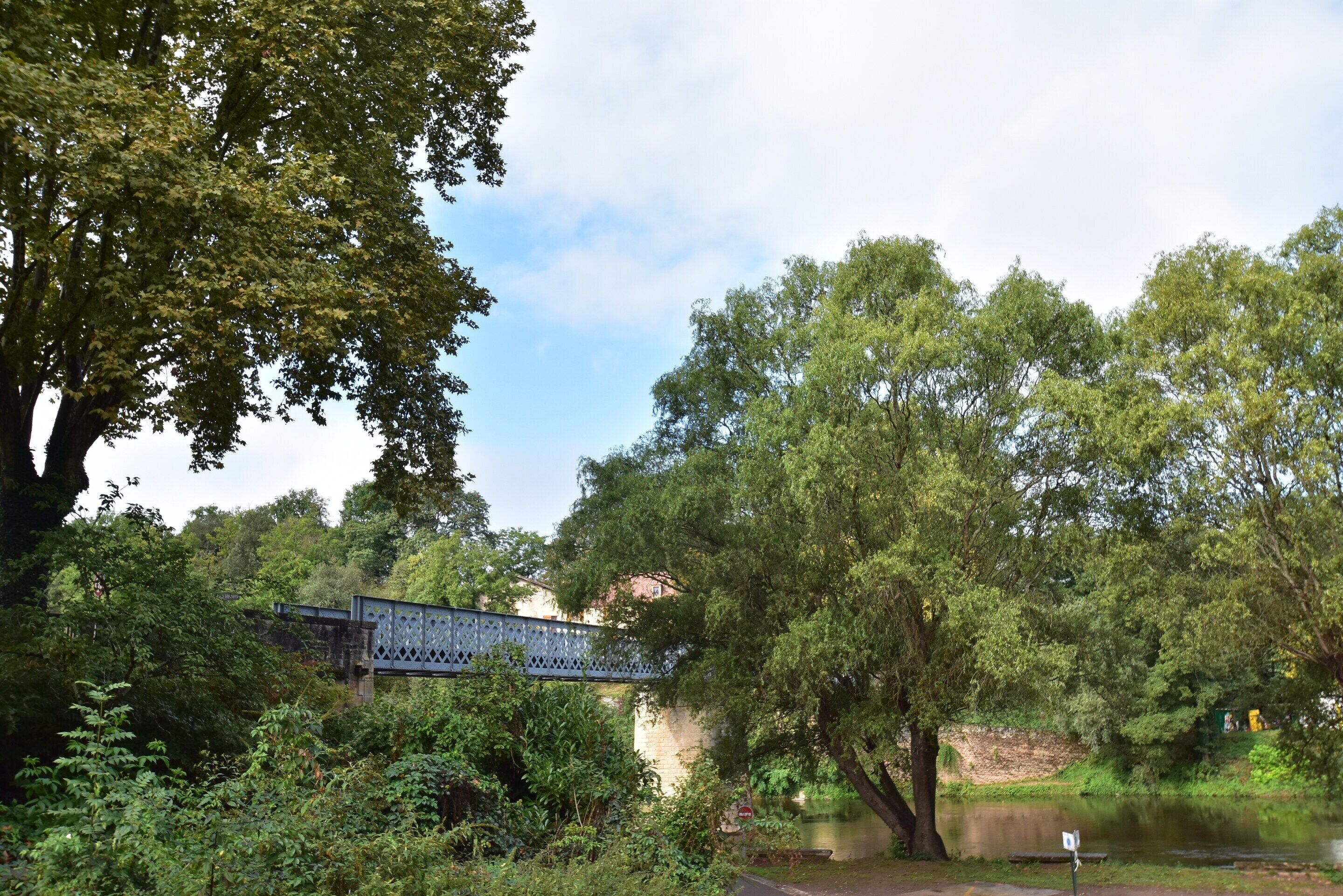 A bridge over a body of water with trees on either side.