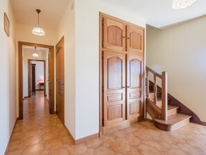 A hallway with wooden doors, a staircase, and a hexagonal tiled floor. - Labardamier Garden Home (Villefranche-du-Perigord)