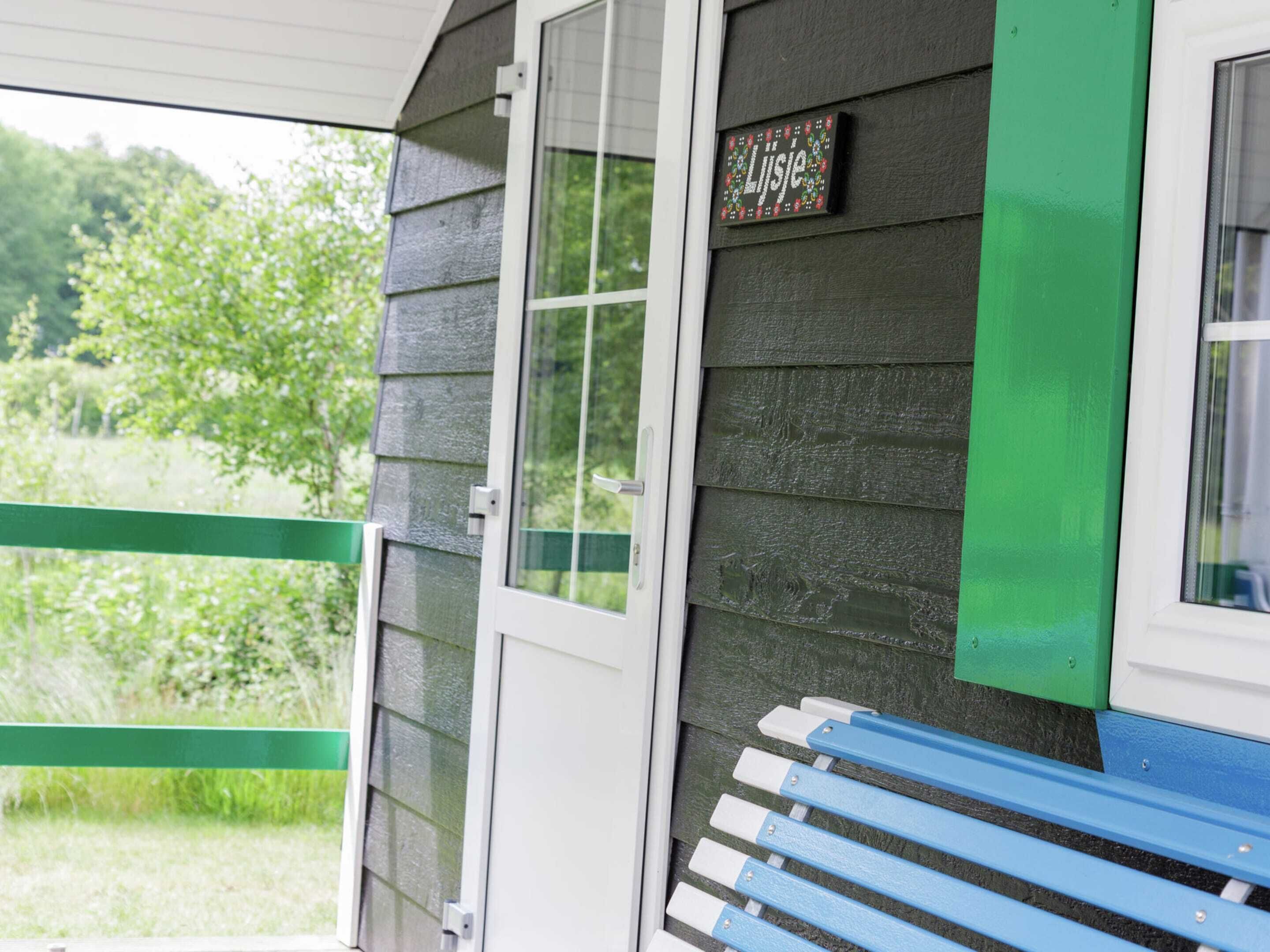 A wooden building with a green door and a sign that reads "Lijse".