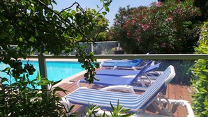 Un espace aménagé au bord de la piscine, avec des chaises longues et une piscine.