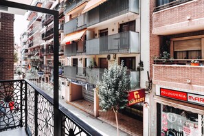 A multi-story residential building with balconies, a small tree, and a storefront with a sign. - GBH Hotel-Apartamentos Posidonia (Benidorm)