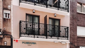 Un edificio de varios pisos con balcones y elaboradas barandas de metal.