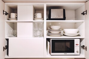 Een koelkast met diepvriezer, een microgolfoven, een kookplaat