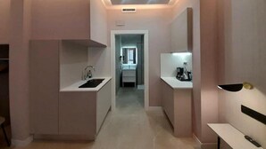 Una cocina moderna con una isla central, un lavaplatos integrado y una encimera con cafetera.