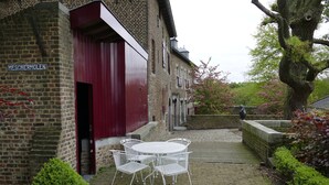 Ein Backsteinhaus mit roter Tür und einem Schild, auf dem "Meschermolen" steht.