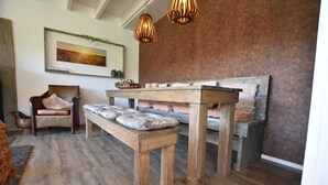 A rustic interior with a wooden bench, a cushioned chair, and a wooden table. - Alluring Holiday Home in Reutum-Weerselo with Hot Tub (Reutum)