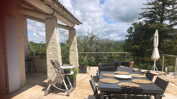 An outdoor patio with a table set for dining, a baby stroller, and a pergola structure. - Holiday Home Provence With Pool (Cereste)