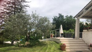 A covered outdoor area with steps leading up to a patio, surrounded by greenery and trees. - Holiday Home Provence With Pool (Cereste)