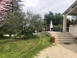 A covered outdoor area with steps leading up to a patio, surrounded by greenery and trees. - Holiday Home Provence With Pool (Cereste)