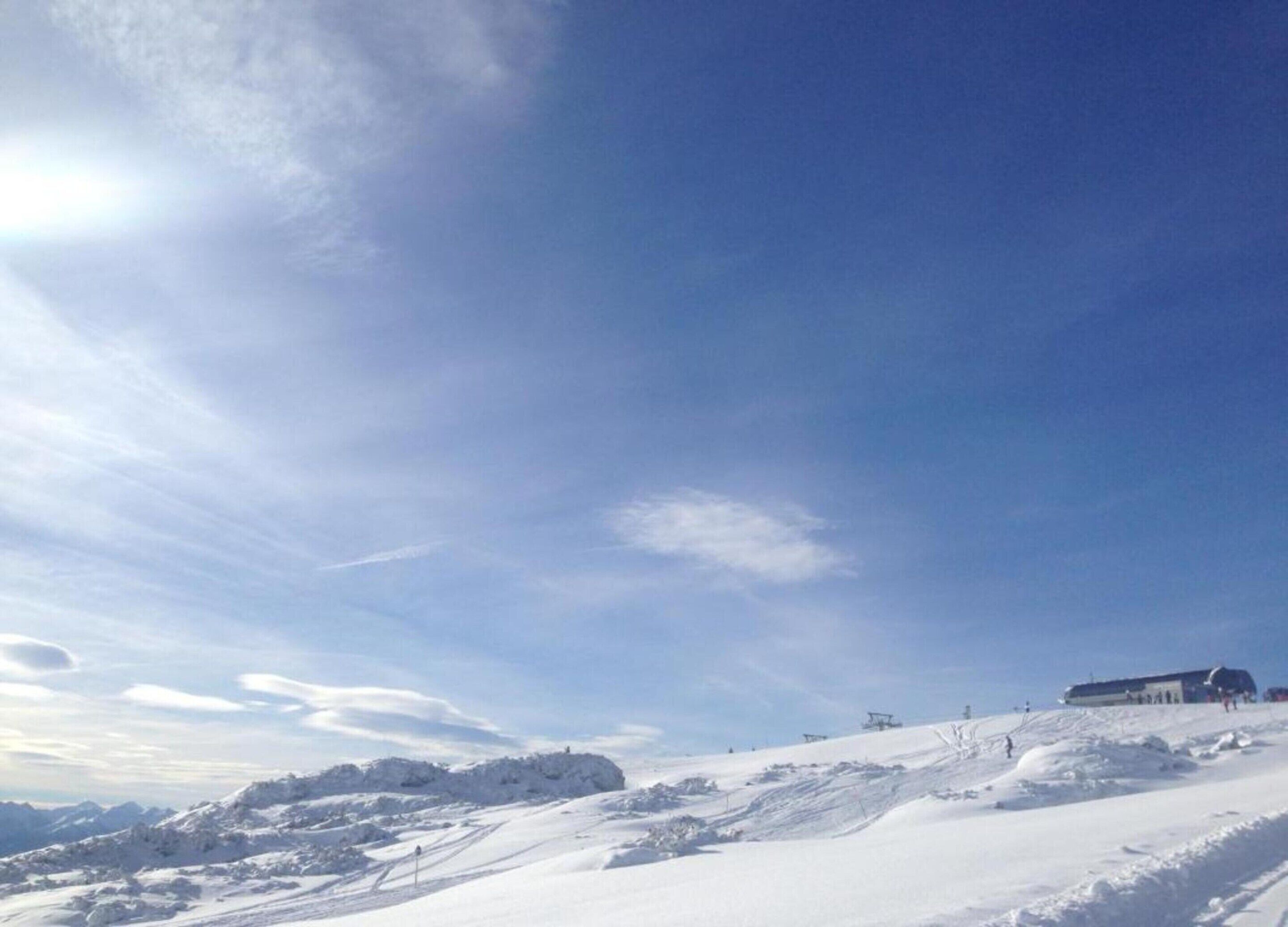 Ett snötäckt landskap med en klar himmel och en byggnad i fjärran.