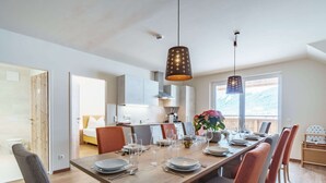 A modern dining area with a wooden table set for six, surrounded by chairs. - Luxurious Apartment in Gosau Near Ski Area (Gosau)