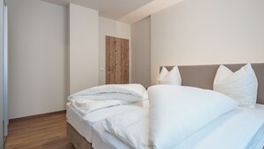 A bedroom with a bed, a wooden door, and a plain wall. - Luxurious Apartment in Gosau Near Ski Area (Gosau)