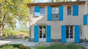 A two-story building with blue shutters, a stone facade, and a view of the countryside. - Villa in Saignon With Pool and Scenic Views (Saignon)