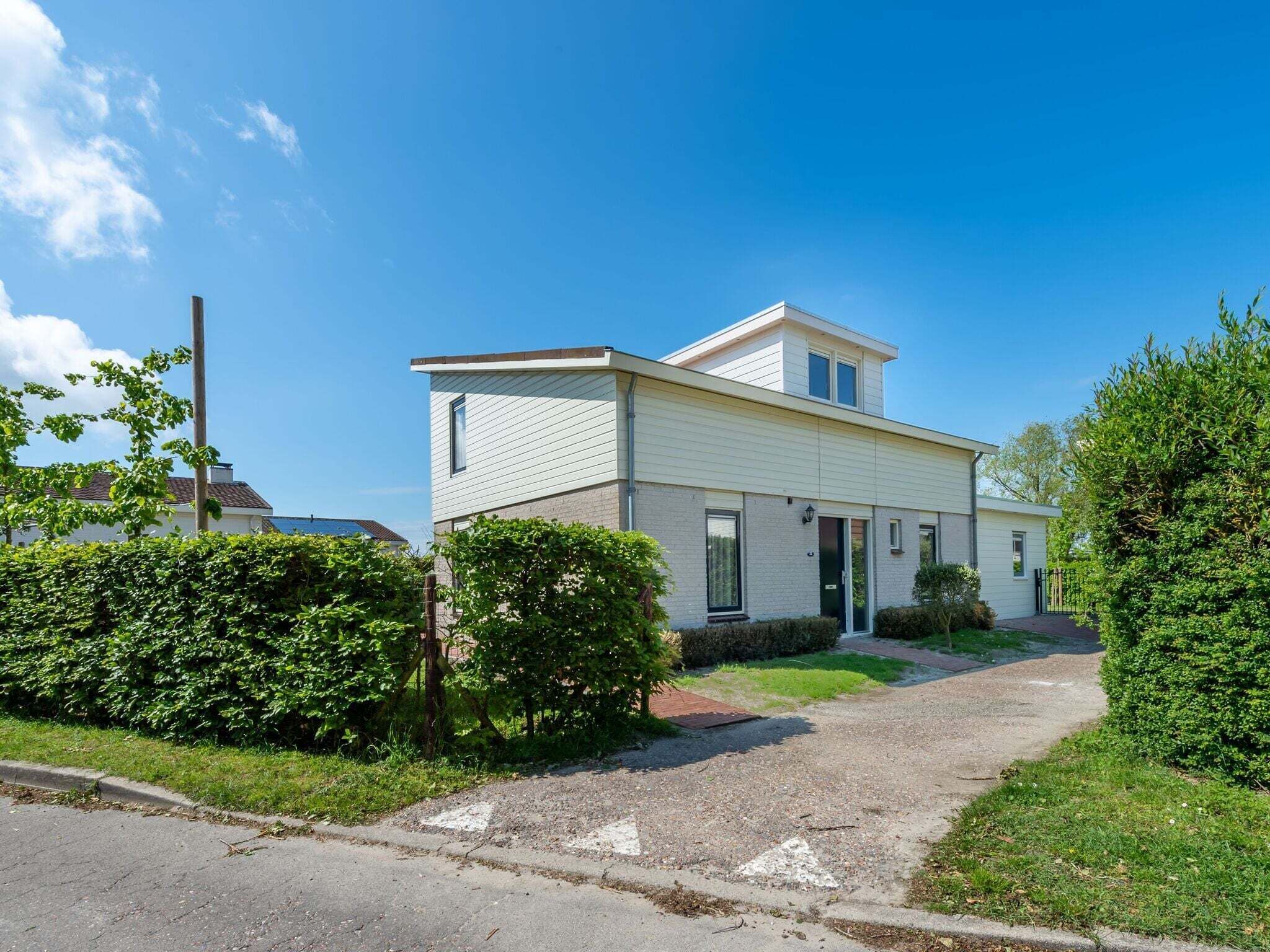 A two-story house with a front entrance, a small porch, and a driveway leading to the front door.