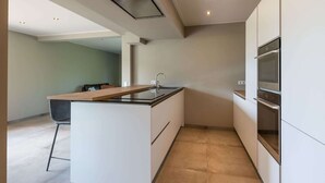 A modern kitchen with a central island, built-in appliances, and a recessed ceiling light. - Detached House Zeeland Near Beach (Kamperland)