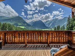 A wooden deck with a view of mountains and a clear sky. - Nationalpark Chalet Schwarzes Horndl (Neukirchen am Grossvenediger)