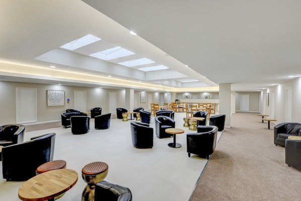 A spacious lounge area with multiple seating options, including sofas and chairs, arranged around tables. - OYO Plymouth Central Hotel (Plymouth)