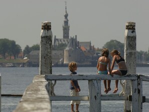 A pier with a view of a historic building in the background. - Pleasant Holiday Home in Kamperland near Sea (Kamperland)