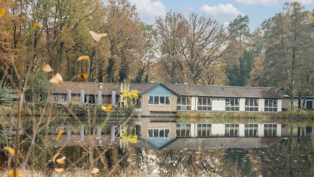 A lakeside building with a reflection in the water, surrounded by trees and vegetation. - Holiday Home in Stramproy Near Nature Reserve (Stramproy)